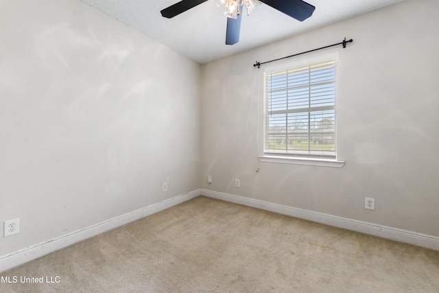 carpeted empty room with ceiling fan, baseboards, and a textured ceiling