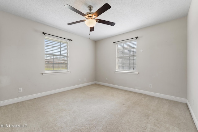 spare room featuring a textured ceiling, carpet floors, ceiling fan, and baseboards