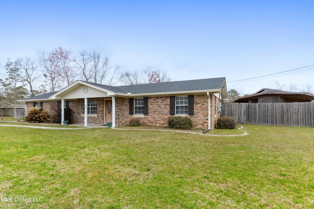 ranch-style house with a front lawn, a shingled roof, fence, and brick siding