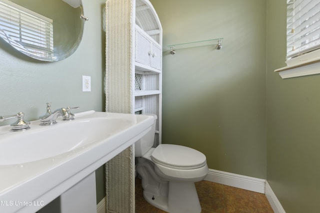 bathroom featuring toilet, tile patterned flooring, and baseboards