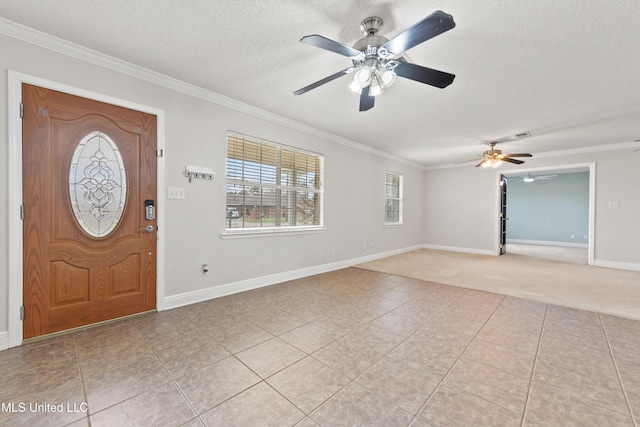 foyer entrance with light tile patterned floors, baseboards, ceiling fan, ornamental molding, and a textured ceiling