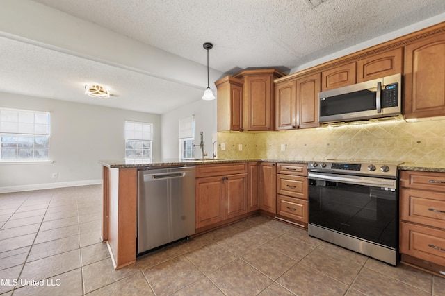 kitchen with stainless steel appliances, plenty of natural light, backsplash, and light stone counters