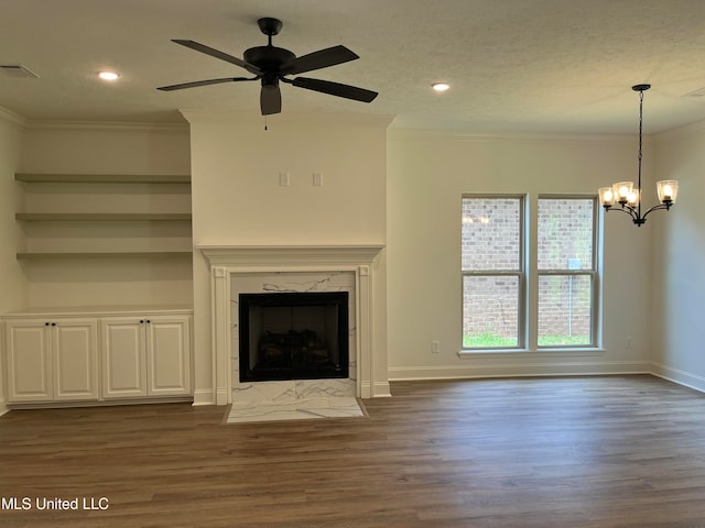 unfurnished living room with a premium fireplace, ornamental molding, dark wood-type flooring, and ceiling fan