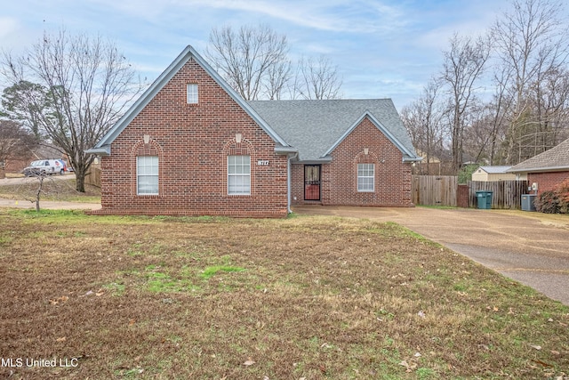 view of front of property with central air condition unit and a front lawn