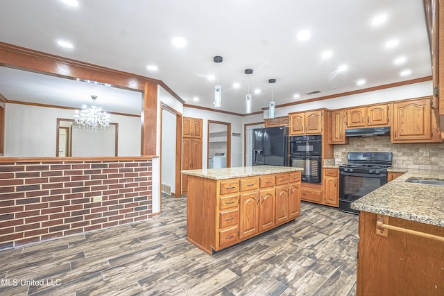 kitchen featuring black appliances, hanging light fixtures, washer / clothes dryer, and a chandelier