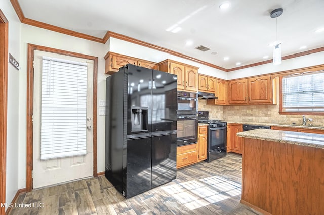 kitchen with sink, light stone counters, dark hardwood / wood-style floors, decorative backsplash, and black appliances