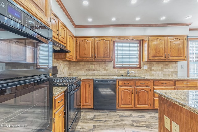 kitchen with sink, backsplash, crown molding, and black appliances