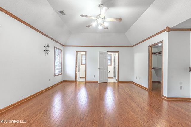 empty room with hardwood / wood-style flooring, plenty of natural light, ceiling fan, and lofted ceiling