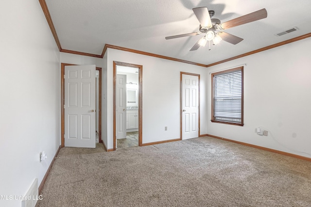 unfurnished bedroom featuring connected bathroom, ceiling fan, crown molding, and carpet floors