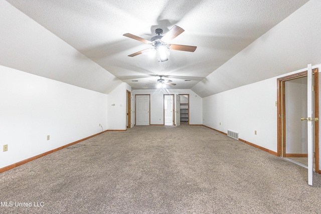 bonus room with carpet floors, a textured ceiling, and vaulted ceiling