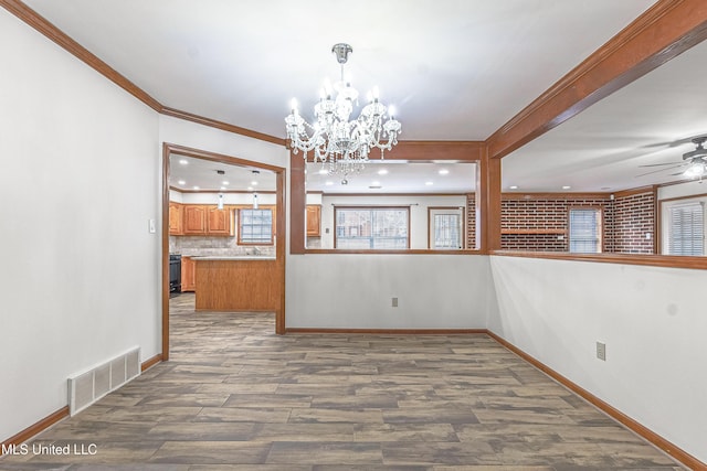 unfurnished dining area featuring hardwood / wood-style flooring, ceiling fan with notable chandelier, and ornamental molding