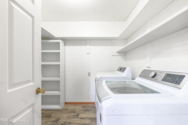 laundry room with washing machine and clothes dryer, dark wood-type flooring, and a textured ceiling