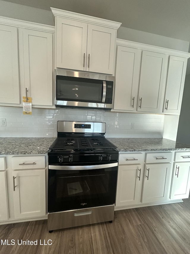 kitchen featuring appliances with stainless steel finishes, light stone countertops, and white cabinets