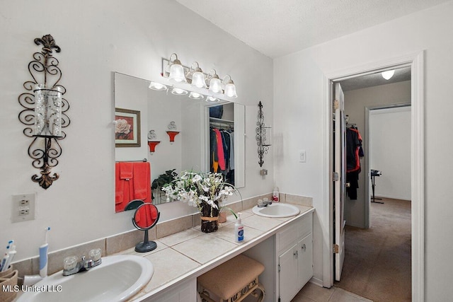 bathroom with vanity, a textured ceiling, and tile patterned floors