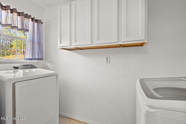 1085 Thomas Dr, Raymond, MS 39154 - laundry room featuring cabinet space, washer and dryer, and light tile patterned floors