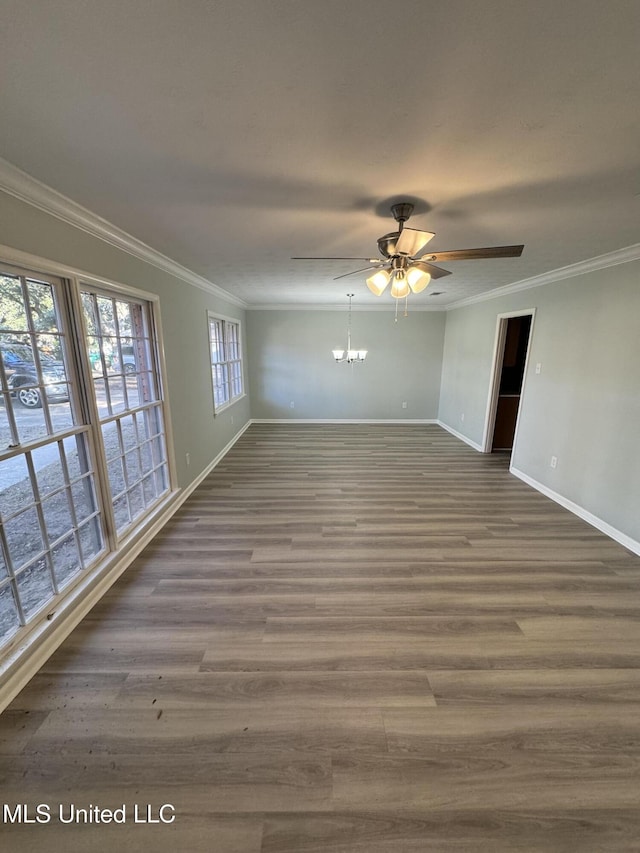 empty room with crown molding, dark wood-type flooring, and ceiling fan with notable chandelier