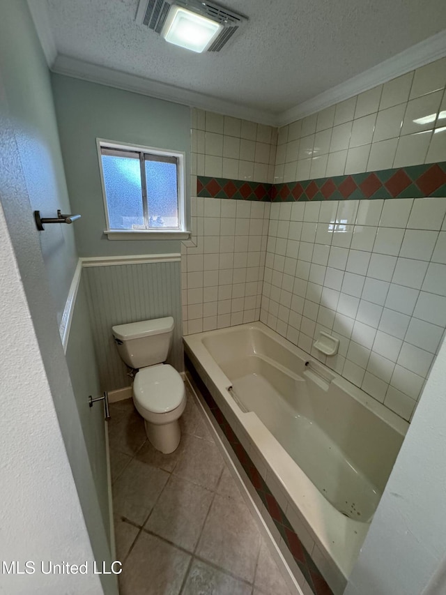 bathroom featuring ornamental molding, tile patterned floors, a textured ceiling, and toilet