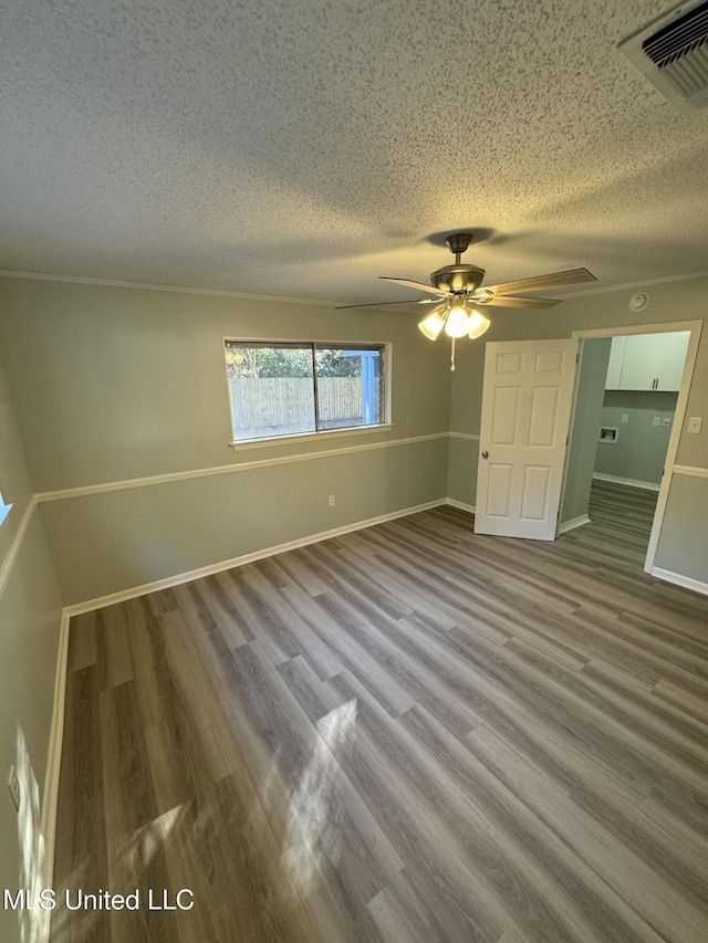 empty room with ceiling fan, hardwood / wood-style flooring, and a textured ceiling