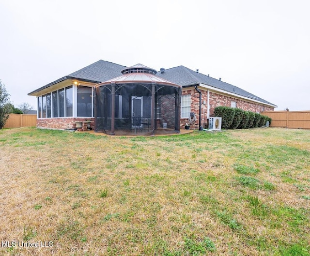 back of property featuring a gazebo, a lawn, and ac unit