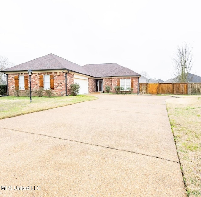 ranch-style house featuring a garage and a front yard