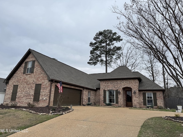 french country style house featuring a garage and a front yard