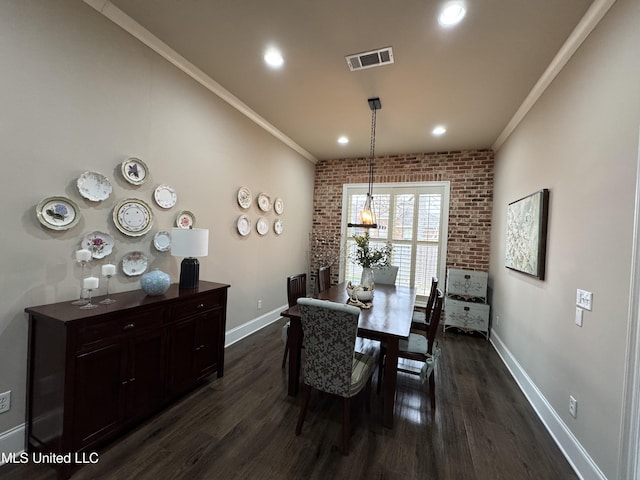 dining space featuring ornamental molding, brick wall, and dark hardwood / wood-style flooring