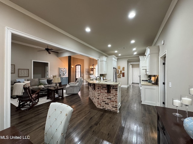 interior space featuring crown molding, ceiling fan, sink, and dark wood-type flooring