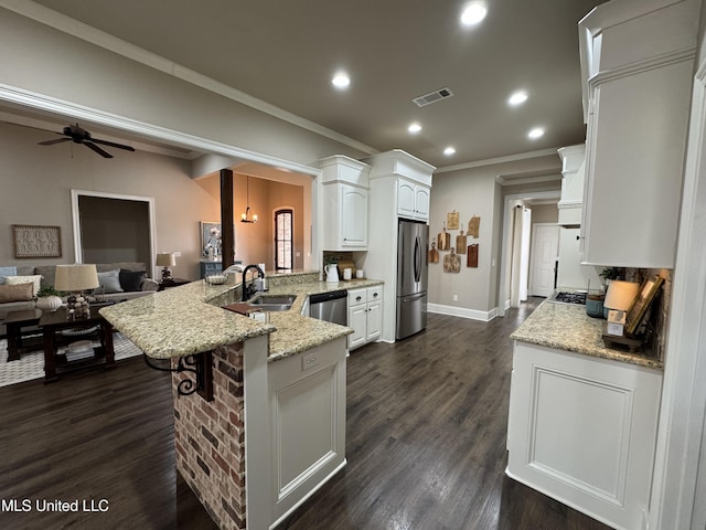 kitchen featuring sink, white cabinetry, appliances with stainless steel finishes, kitchen peninsula, and light stone countertops