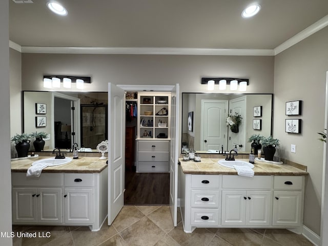 bathroom with ornamental molding, a shower with shower door, tile patterned flooring, and vanity