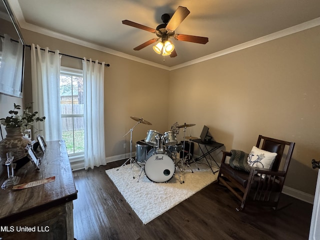 game room with dark wood-type flooring, ceiling fan, and crown molding