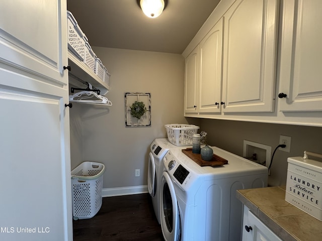 laundry area with cabinets, dark wood-type flooring, and washer and clothes dryer