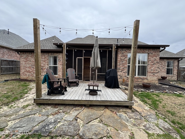 rear view of property featuring a wooden deck and an outdoor fire pit