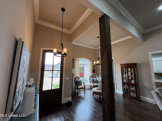 entryway featuring ornamental molding, dark hardwood / wood-style floors, a chandelier, and a high ceiling