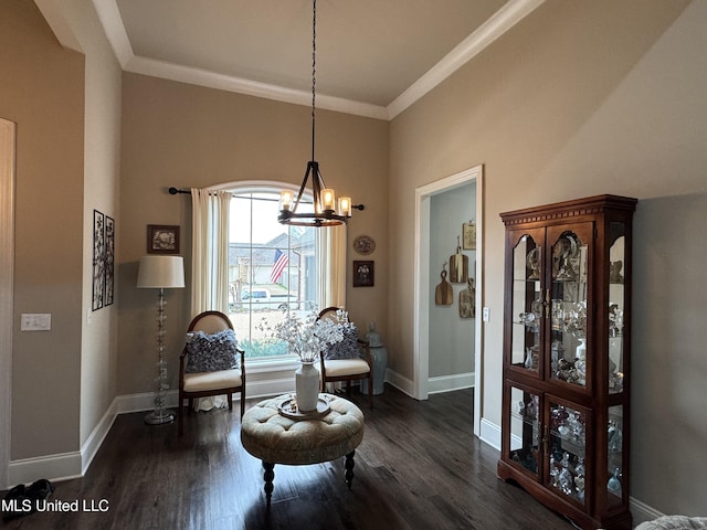 sitting room with a notable chandelier, crown molding, and dark wood-type flooring