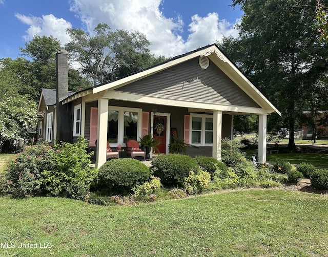 view of front of property featuring covered porch and a front lawn