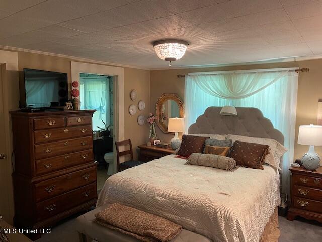 carpeted bedroom featuring ornamental molding