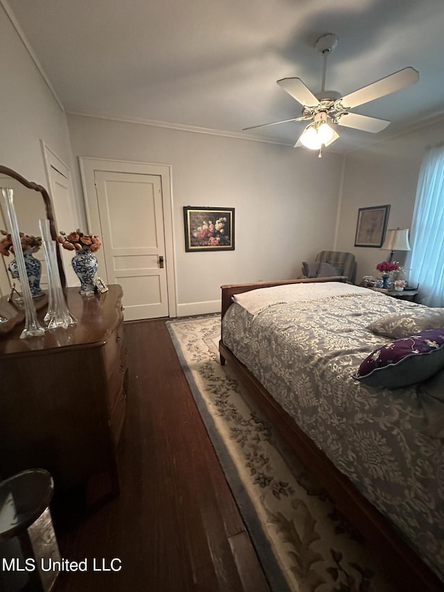 bedroom featuring dark wood-type flooring, ceiling fan, and crown molding