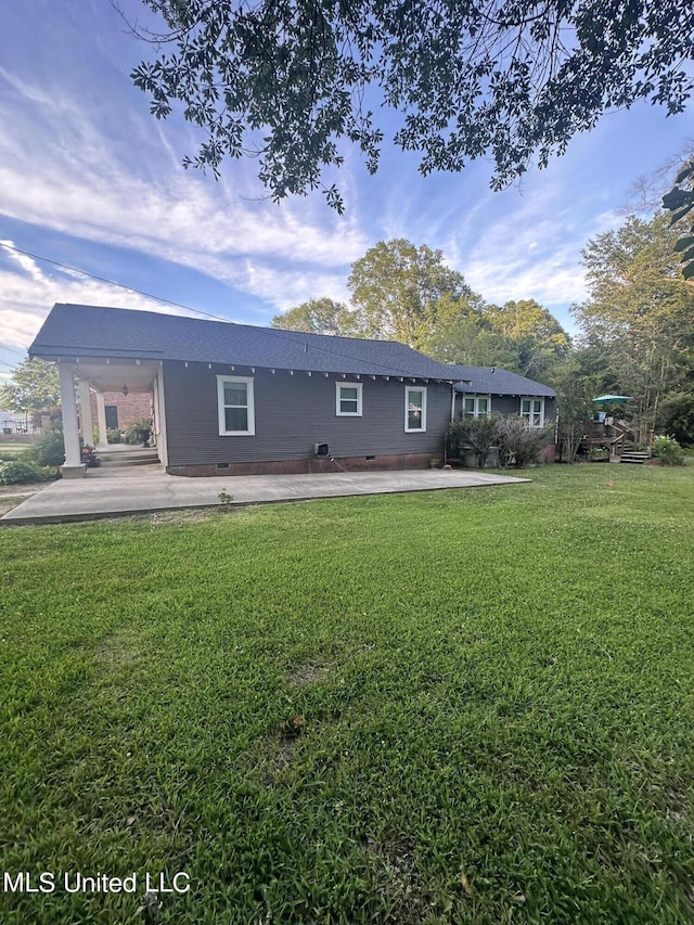 back of house with a patio and a lawn