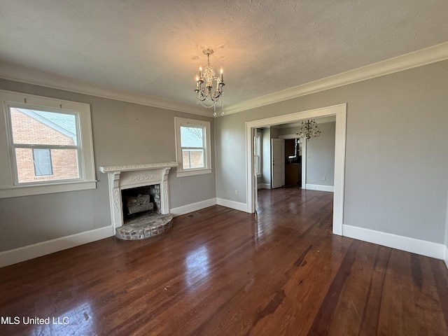 209 S Jackson St, Crystal Springs, MS 39059 - unfurnished living room with crown molding, a notable chandelier, a brick fireplace, and dark wood-type flooring