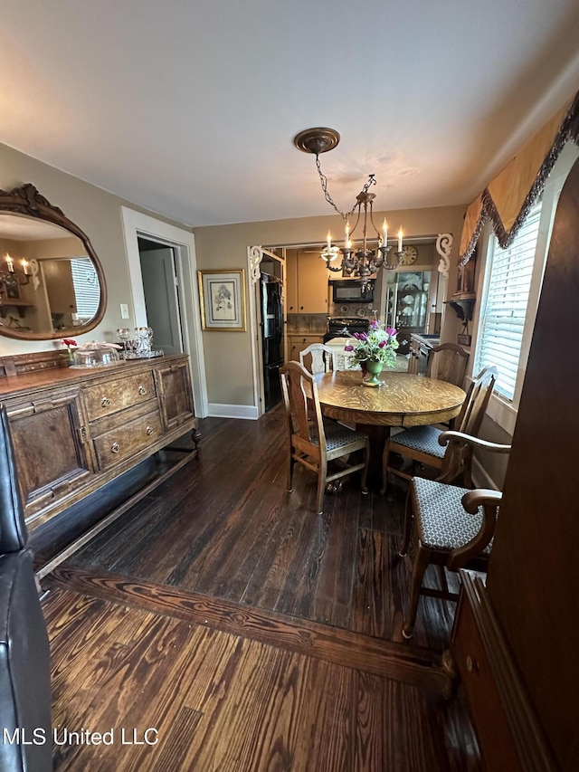 209 S Jackson St, Crystal Springs, MS 39059 - dining room featuring baseboards, a notable chandelier, and dark wood-style flooring