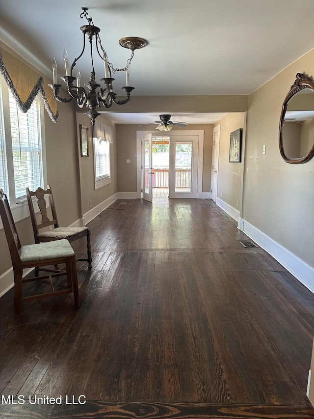 209 S Jackson St, Crystal Springs, MS 39059 - unfurnished dining area featuring dark wood-style floors, baseboards, and ceiling fan with notable chandelier