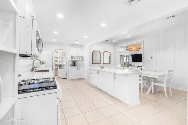 kitchen with a breakfast bar, a center island, white cabinets, and light tile patterned floors