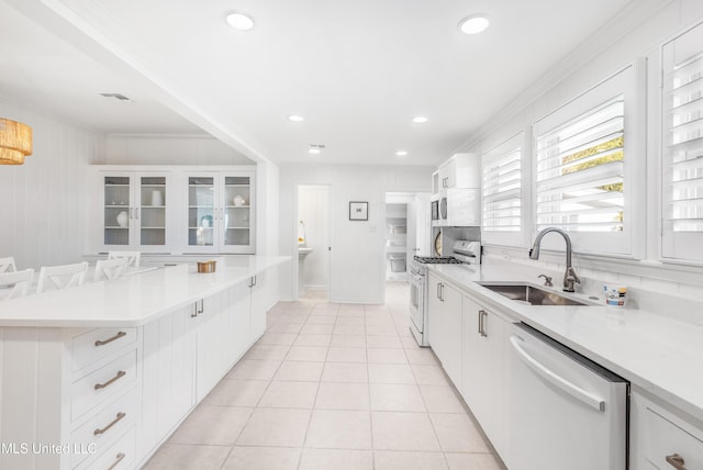 kitchen featuring sink, light tile patterned floors, crown molding, white appliances, and white cabinets