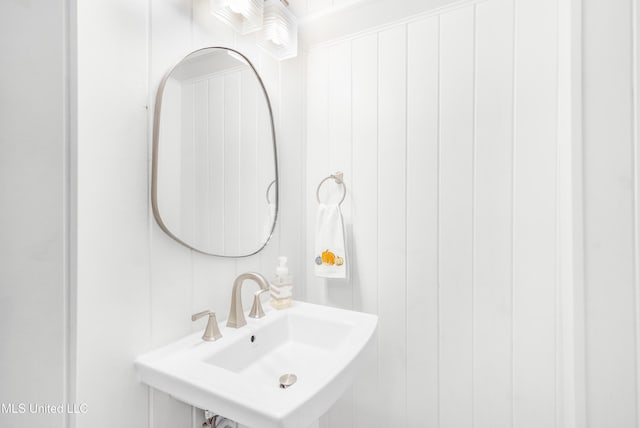 bathroom with wood walls and sink