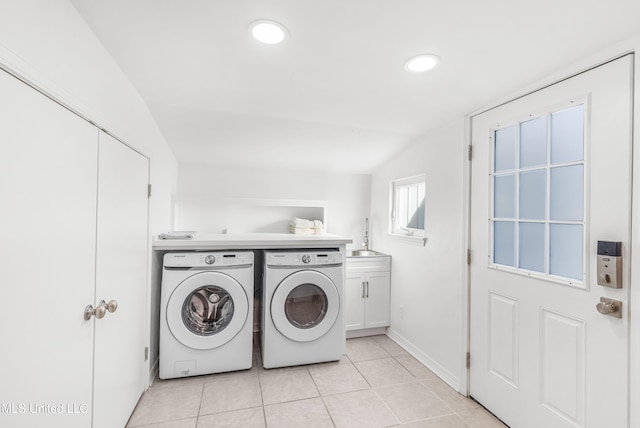 laundry area with washer and clothes dryer, cabinets, light tile patterned floors, and sink