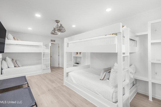 bedroom featuring ornamental molding and light wood-type flooring