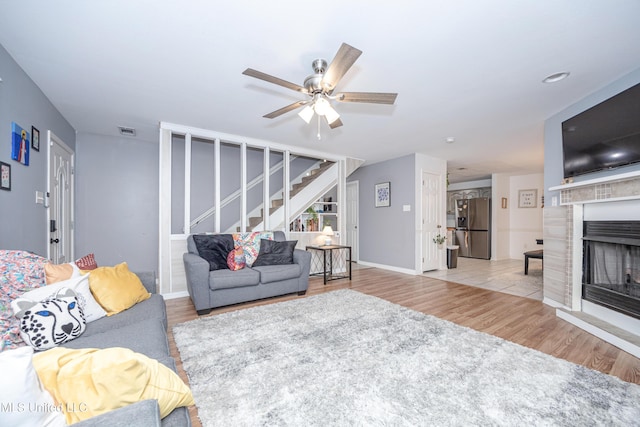 living room with light hardwood / wood-style floors and ceiling fan