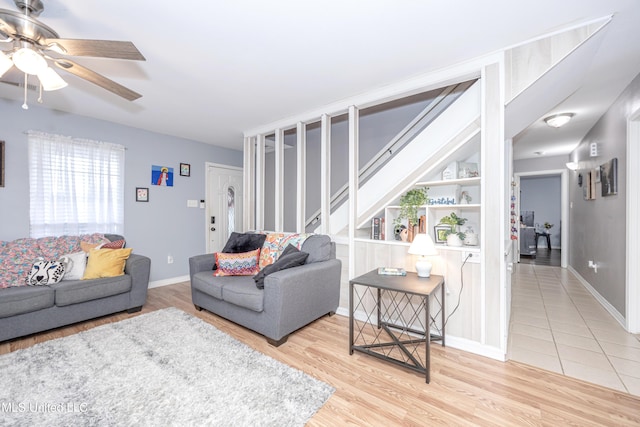 living room featuring ceiling fan, built in features, and hardwood / wood-style flooring