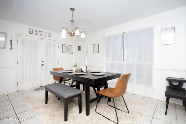 tiled dining space featuring a notable chandelier