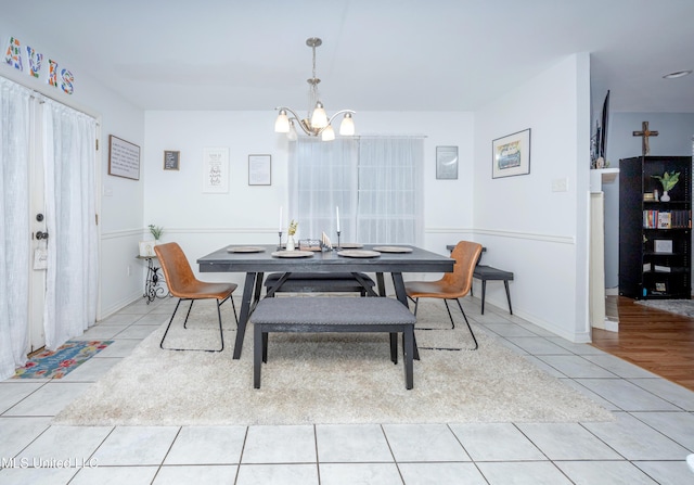 tiled dining room with a chandelier